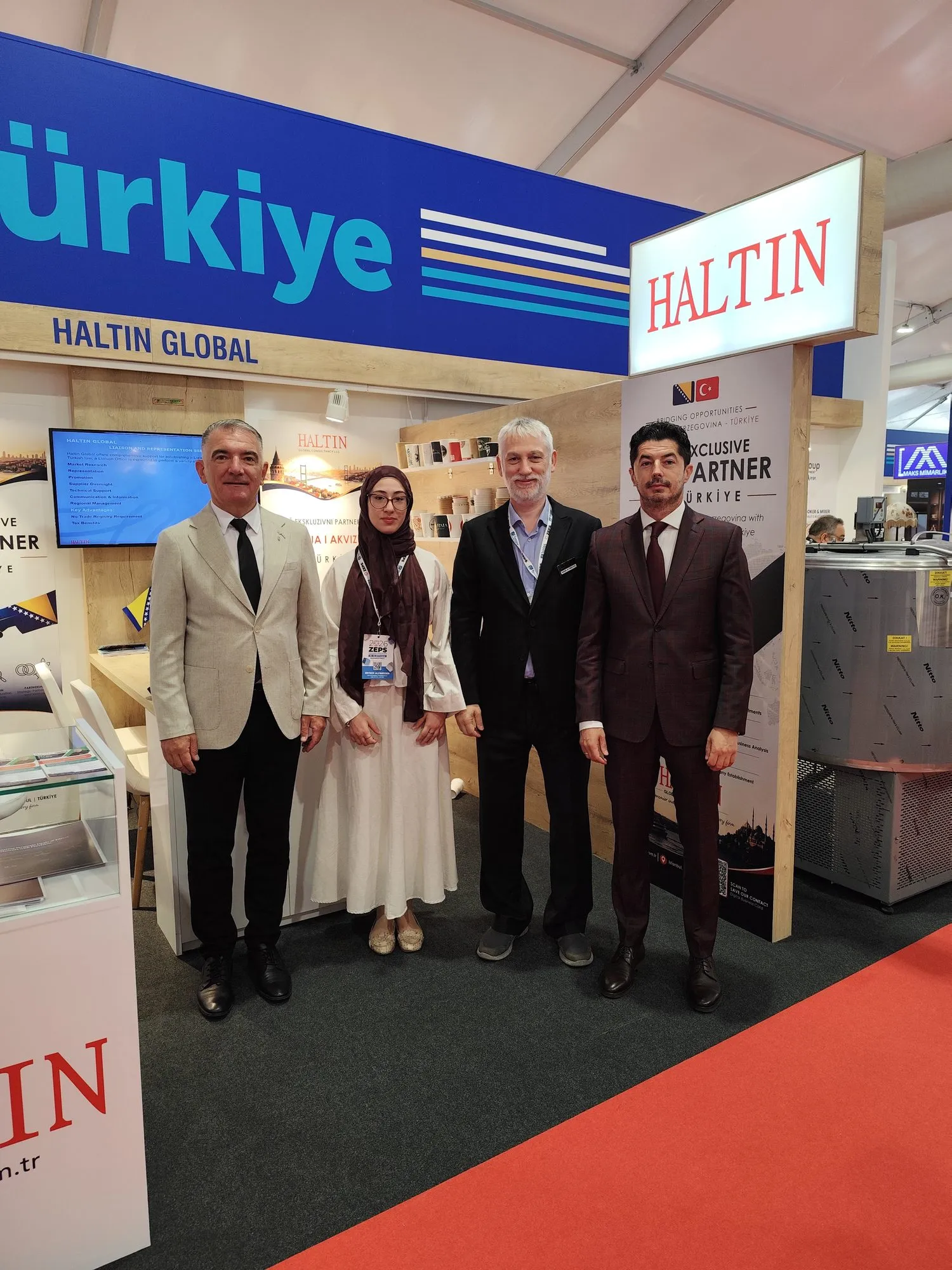 ZEPS 2026 Fuarı'nda HALTIN tabelasının yanında, Haltin standında poz veren dört kişi