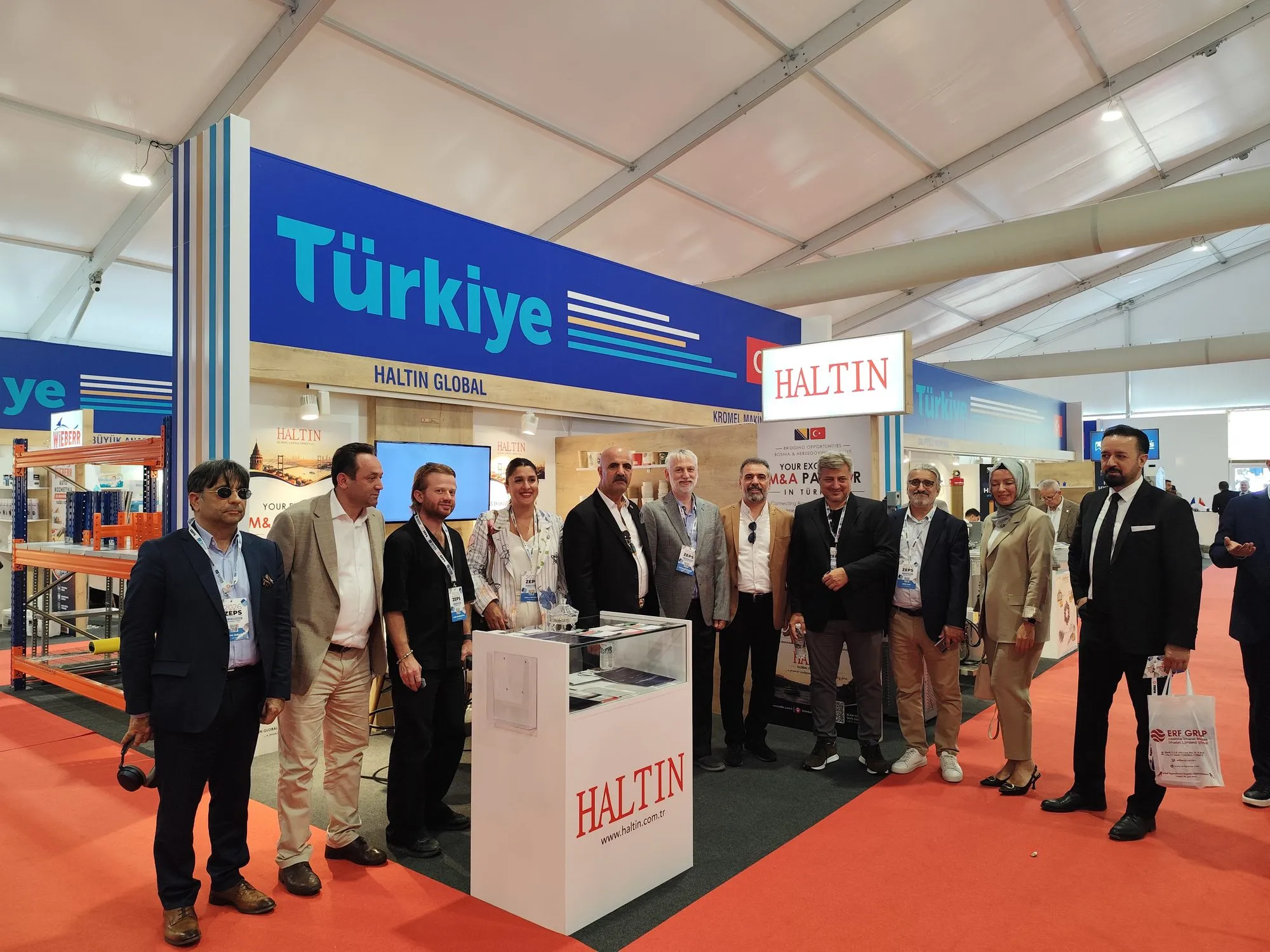 ZEPS 2026 Fuarı'nda Haltin standında toplu fotoğraf çektiren kalabalık bir ziyaretçi grubu